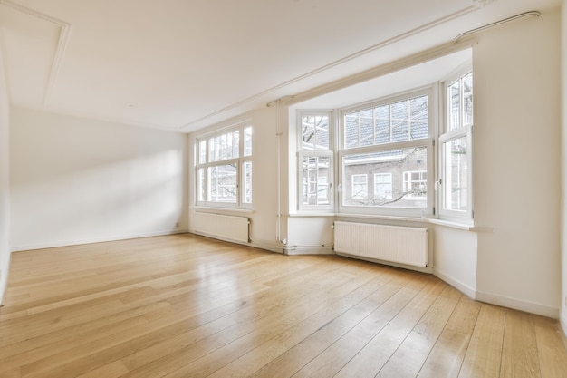 Habitación con ventanas y suelo de parquet.