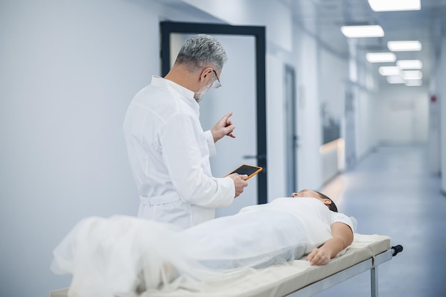 Hablando con el paciente Un médico hablando con un paciente antes del procedimiento de resonancia magnética