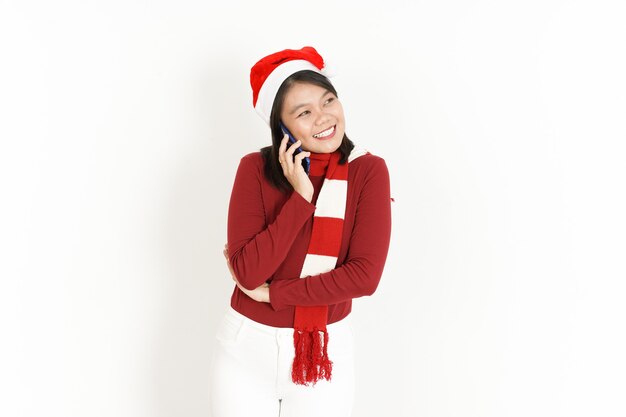 Hablando por teléfono con expresión de cara feliz de mujer asiática con cuello alto rojo y gorro de Papá Noel