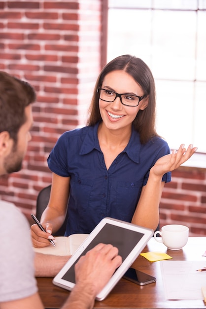 Foto hablar de un nuevo proyecto creativo. dos hombres de negocios alegres en ropa casual hablando y gesticulando mientras están sentados cara a cara en la mesa