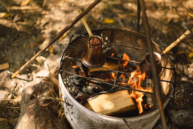 Hacer café en la hoguera hacer café o té en el fuego del equipamiento turístico de la naturaleza