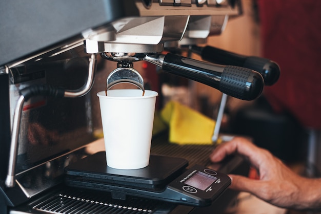 Hacer café en una taza desechable con una máquina de café