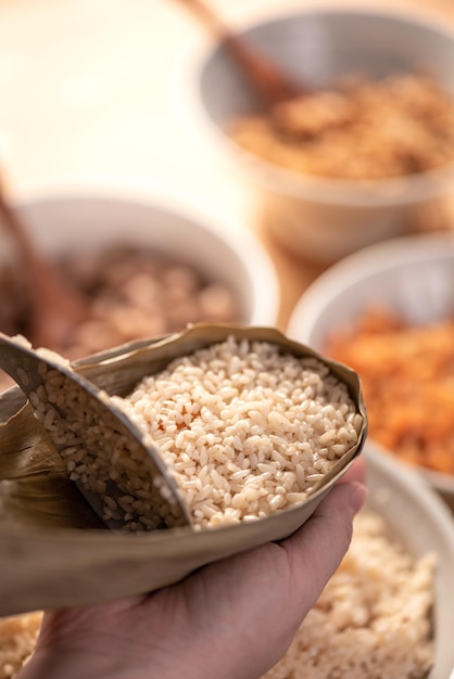 Hacer comida zongzi preparar y envolver bolas de arroz chino en casa para el estilo de vida de celebración del Festival del Bote del Dragón de Duanwu