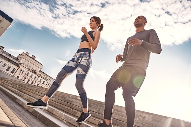 Hacer ejercicio en el retrato de aire fresco de una joven pareja de deportes haciendo ejercicio matutino en un