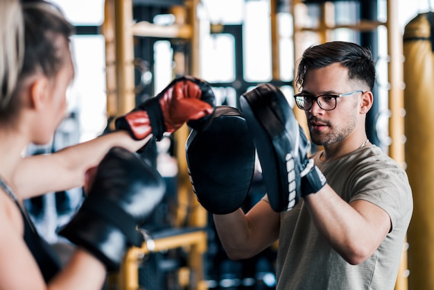 Foto hacer ejercicios con guantes de boxeo y un compañero o entrenador de repuesto.