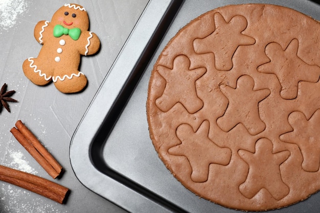 Hacer galletas caseras de hombre de jengibre en una mesa gris plana