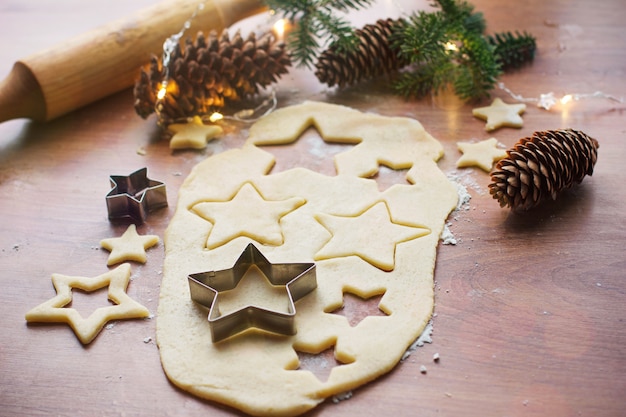 Hacer galletas de Navidad en una mesa de madera con varios accesorios, preparándose para Navidad y Año Nuevo