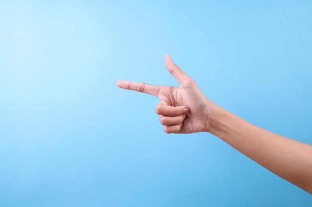 Hacer el gesto de la mano apuntando a la izquierda contra un fondo azul