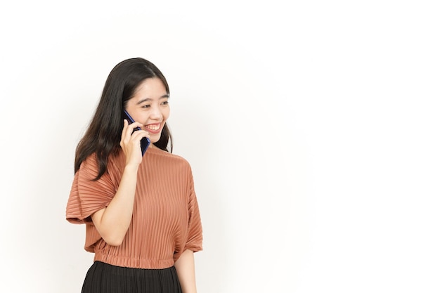 Hacer una llamada telefónica usando el teléfono inteligente de una hermosa mujer asiática aislada en el fondo blanco