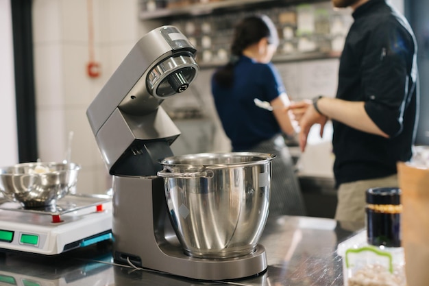 Hacer macarons Una batidora de mesa de cocina plateada amasa la masa para macarons