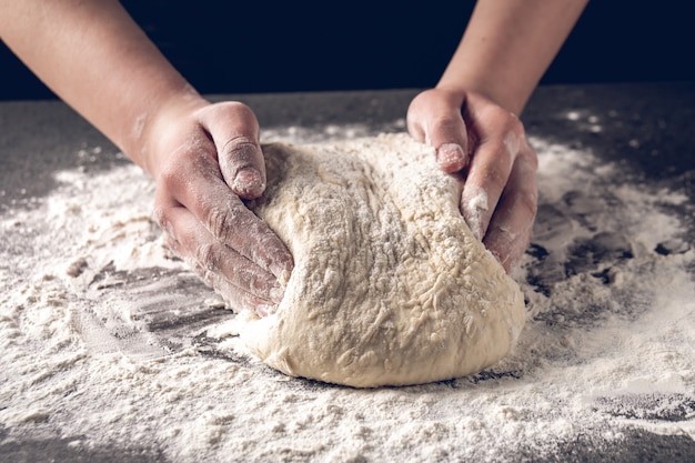 Hacer masa por manos femeninas en panadería