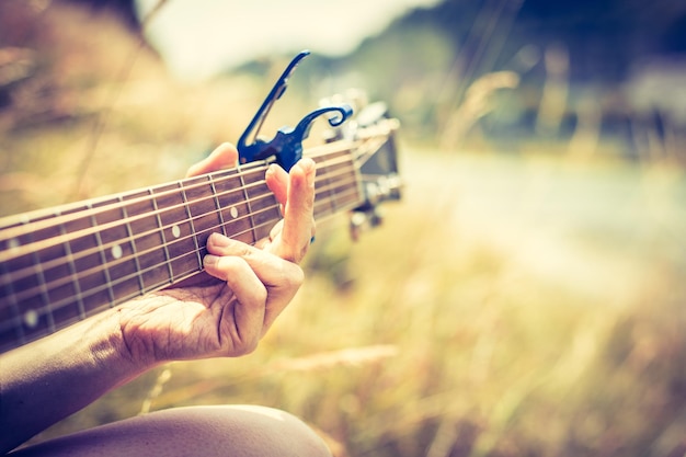 Hacer música al aire libre El joven toca la guitarra de cerca