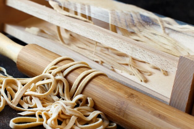 Hacer pasta tagliolini alla chitarra con una herramienta de cerca