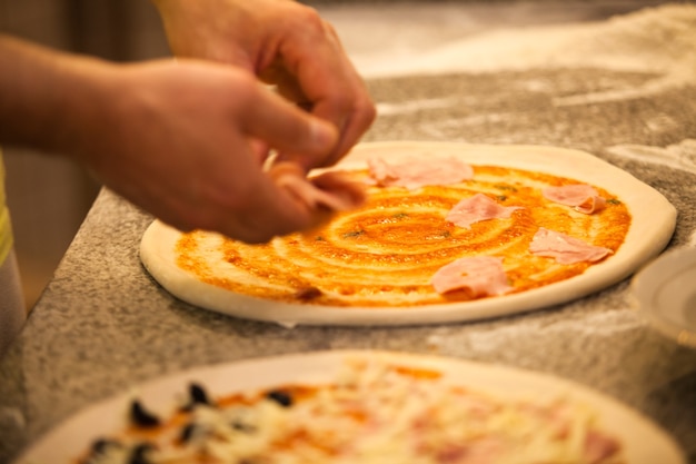 Hacer pizza en el restaurante, cerrar las manos del chef