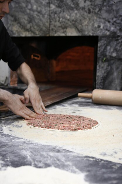 Hacer una pizza turca o comida rápida lahmacun y comida callejera popular en los países mediterráneos