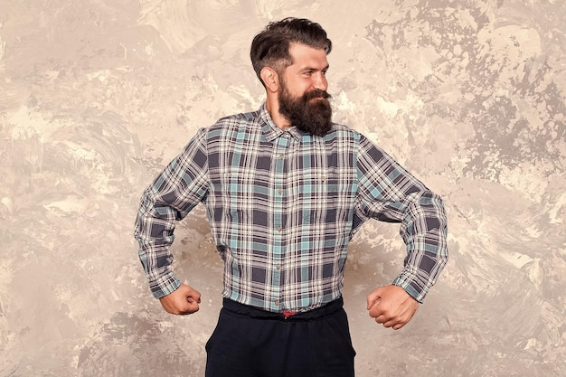 Hacer que el cabello sea más fuerte poder masculino en estilo hombre con barba de moda y bigote hipster en barbería peluquero profesional en camisa a cuadros mostrar músculos brutal hombre barbudo fondo grunge