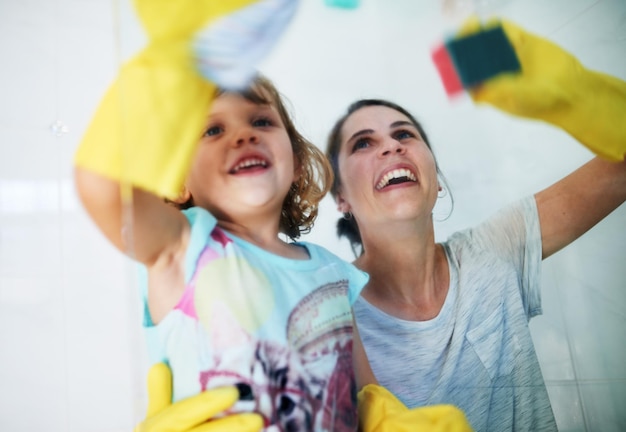 Hacer que las tareas del hogar sean divertidas Foto de una madre y su hija haciendo tareas juntas en casa