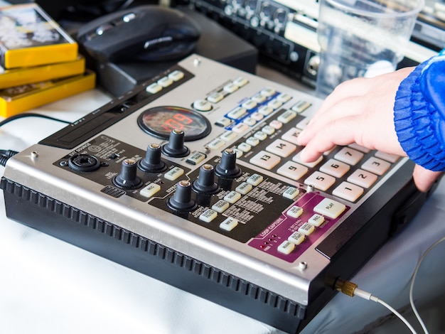 Hacer ritmos de hip hop en un controlador de caja de ritmos y tocadiscos en un estudio en casa