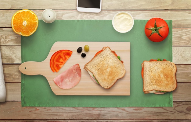 Hacer sándwich en tabla de cortar en la vista superior de la hora del desayuno