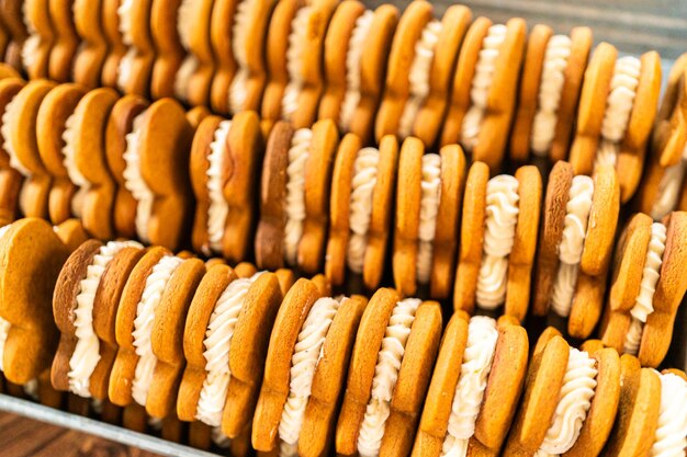 Hacer sándwiches de pan de jengibre festivo en una mesa de madera rústica