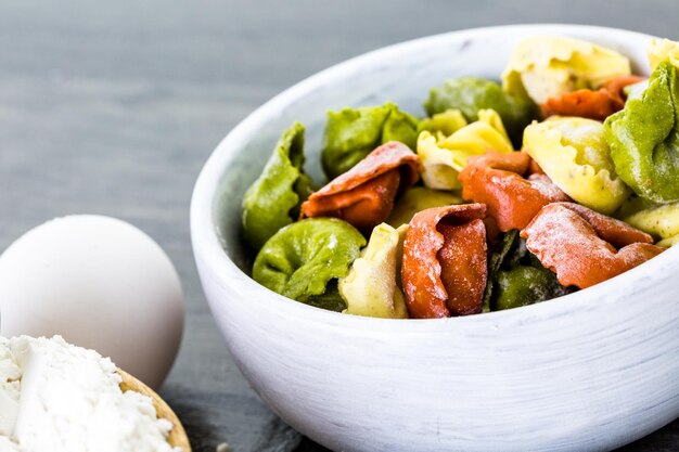 Hacer tortellini de queso arcoíris fresco con productos orgánicos.