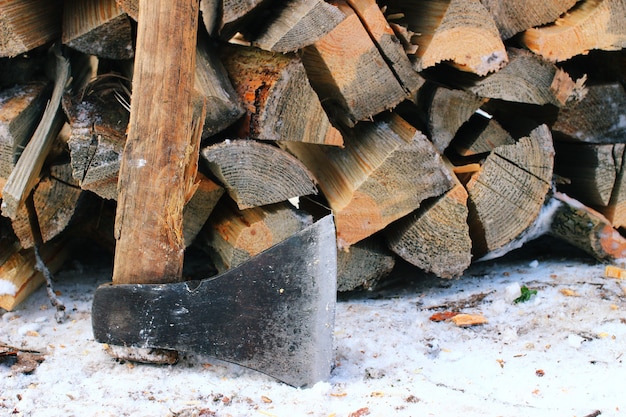 Foto hacha y madera en invierno.