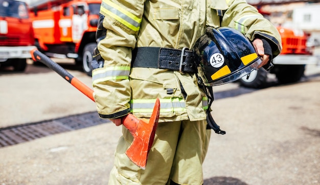 Hacha en un primer plano de manos de bomberos