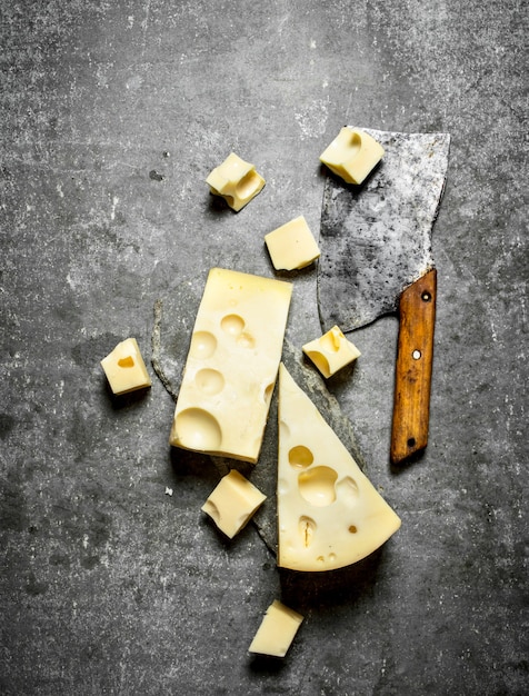 Hacha y trozos de queso fresco. Sobre la mesa de piedra.