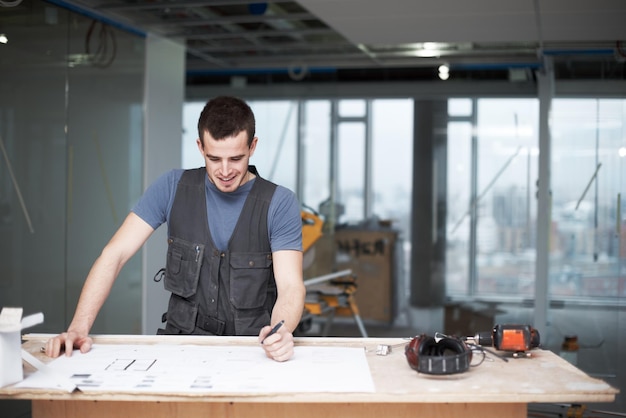 Haciendo algunos cambios rápidos Arquitecto joven trabajando en sus planes mientras está en un sitio de construcción