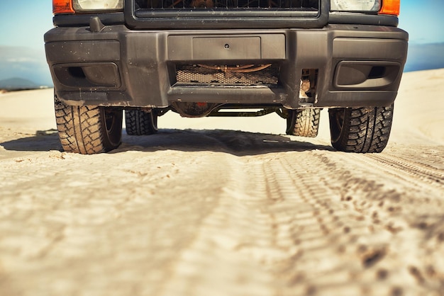 Haciendo caminos a través del desierto Toma de un 4x4 pesado conduciendo a lo largo de unas dunas de arena