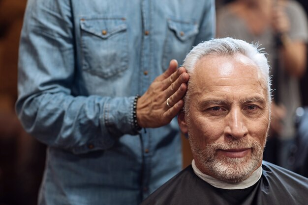 Haciendo lucir perfecto. Cerca del peinado del peluquero con un gel especial.