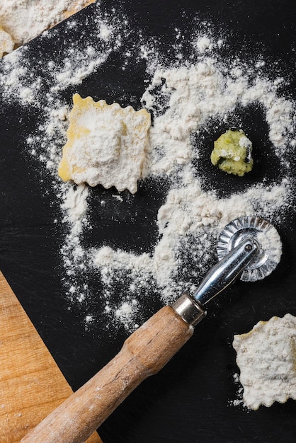 Haciendo raviolis cortando la masa rellenando la pasta italiana