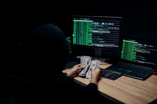 Hacker anónimo contando dinero