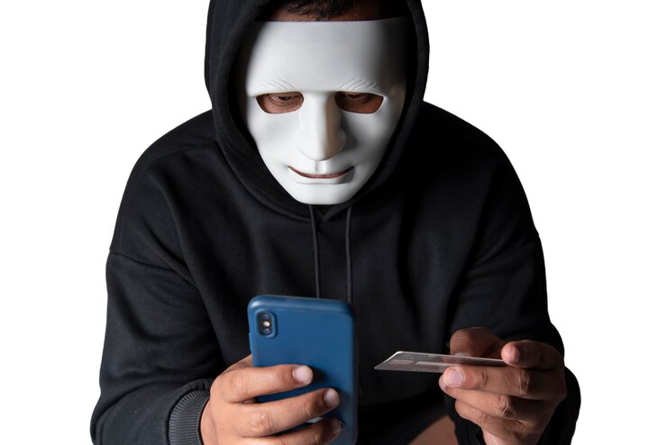Foto un hacker anónimo enmascarado está usando un teléfono inteligente para penetrar la información financiera de la tarjeta de crédito con un camino de recorte concepto de piratería y malware