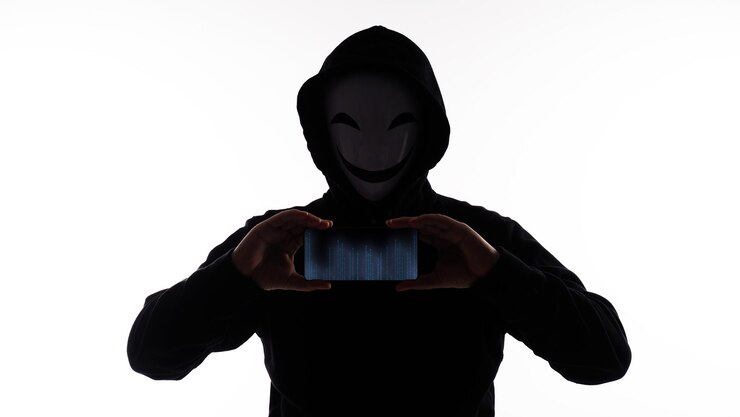 Foto hacker anónimo y mascarilla con smartphone en mano