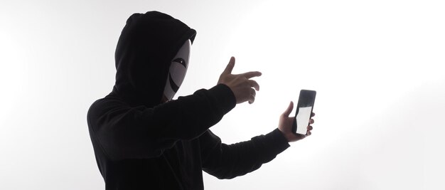 Foto hacker anonymous und gesichtsmaske mit smartphone in der hand