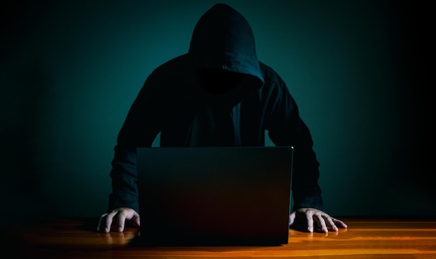 Hacker arbeiten im Dunkeln an Laptops Das Konzept der Informationssicherheit im Internet-Netzwerk und Informationsspionage