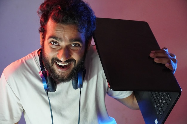 Un hacker chico con laptop y cara sonriente.