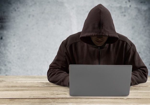 Hacker cibernético usando laptop sobre fondo oscuro