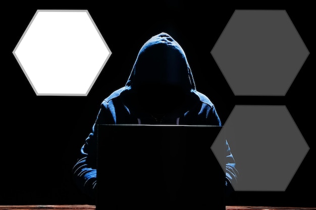 Un hacker con una computadora portátil se sienta en una mesa y un código binario abstracto Programas virtuales de amenazas para la vida comercial