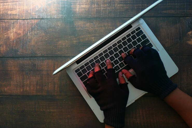 Foto hacker encapuchado robando datos de la computadora portátil por la noche