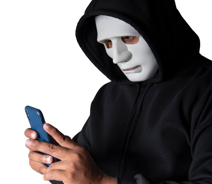 Foto un hacker enmascarado anónimo está utilizando teléfonos inteligentes para penetrar datos financieros con el concepto de malware y piratería de ruta de recorte