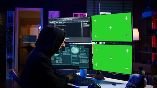 Hacker entwickeln Spyware auf einem Computer mit grünem Bildschirm, um Daten zu stehlen