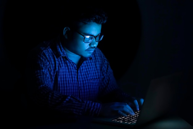 Hacker escribiendo código de programación a última hora de la noche