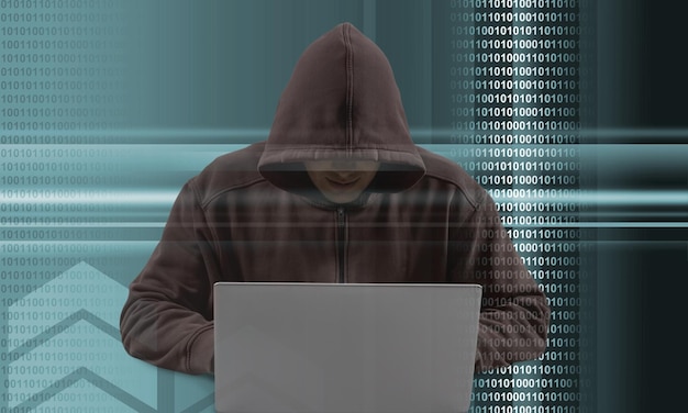 Hacker escribiendo en una computadora portátil con código binario en el fondo