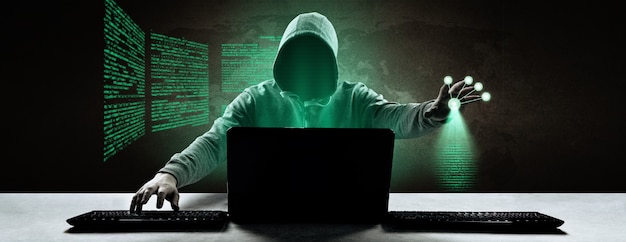 Hacker imprime um código em um teclado de laptop para invadir um ciberespaço