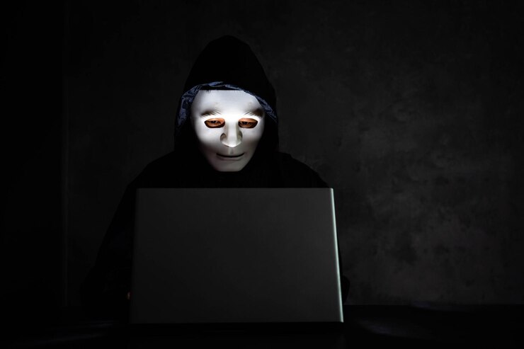 Foto hacker informático usando portátil en la mesa contra la pared