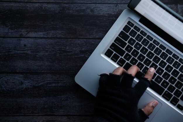 Hacker mano robando datos de la computadora portátil de arriba hacia abajo.