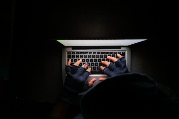 Hacker mano robando datos de la computadora portátil de arriba hacia abajo.
