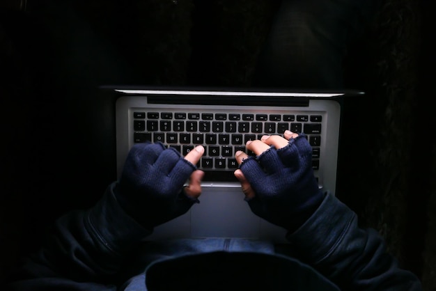 Hacker mano robando datos de la computadora portátil de arriba hacia abajo.